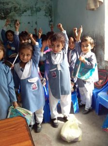 Little kids raise hands for needing a jacket.